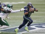 Seattle Seahawks quarterback Russell Wilson, right, scrambles against the New York Jets during the first half of an NFL football game, Sunday, Dec. 13, 2020, in Seattle. (AP Photo/Ted S.