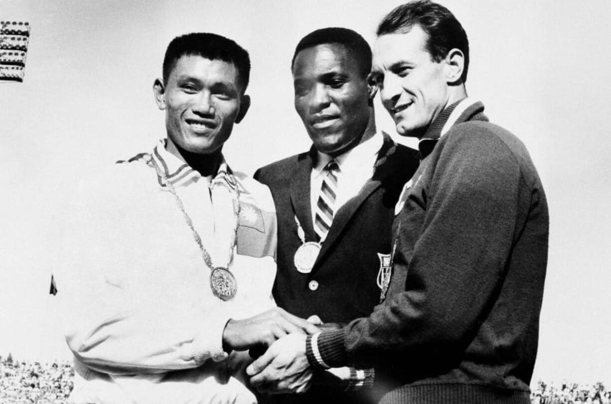 FILE - In this Sept. 7, 1960, file photo, Rafer Johnson of Kingsburg, Calif., is flanked by runners-up, Chuan-Kwang Yang, left, of Taiwan, and Vasily Kuznetsov of Russia, as they join in three-way handshake after receiving medals for the decathlon event of the Olympics in Rome, Italy. Rafer Johnson, who won the decathlon at the 1960 Rome Olympics and helped subdue Robert F. Kennedy&#039;s assassin in 1968, died Wednesday, Dec. 2, 2020. He was 86. He died at his home in the Sherman Oaks section of Los Angeles, according to family friend Michael Roth.