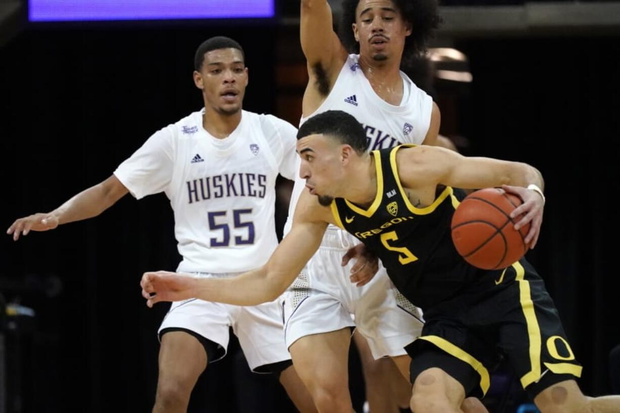 Oregon&#039;s Chris Duarte (5) tries to get past Washington&#039;s Quade Green (55) and Nate Pryor during the first half of an NCAA college basketball game Saturday, Dec. 12, 2020, in Seattle.