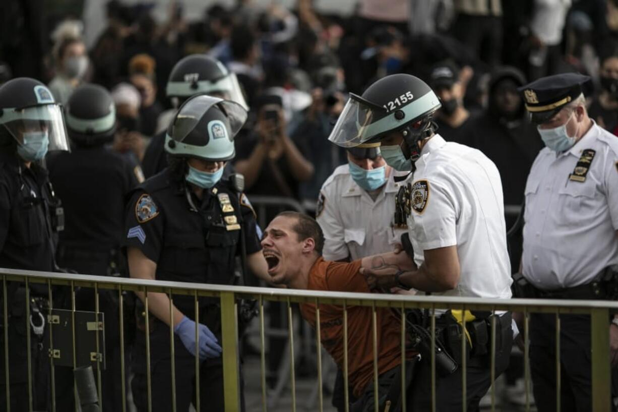 FILE -- In this June 1, 2020 file photo, New York City Police officers arrest a man during a solidarity rally calling for justice over the death of George Floyd, in the Brooklyn borough of New York. The New York Police Department was caught off guard by the size and scope of the spring protests sparked by the police killing of George Floyd in Minneapolis and resorted to disorder control tactics that stoked tensions and stifled free speech rights, the city&#039;s inspector general said in a report released Friday, Dec. 18, 2020.