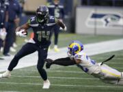 Seattle Seahawks wide receiver DK Metcalf (14) runs after a reception as Los Angeles Rams cornerback Troy Hill (22) attempts the tackle during the first half of an NFL football game, Sunday, Dec. 27, 2020, in Seattle.