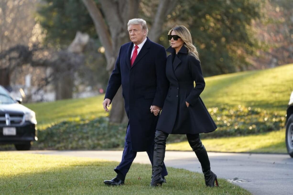 President Donald Trump and first lady Melania Trump walk to board Marine One on the South Lawn of the White House, Wednesday, Dec. 23, 2020, in Washington.