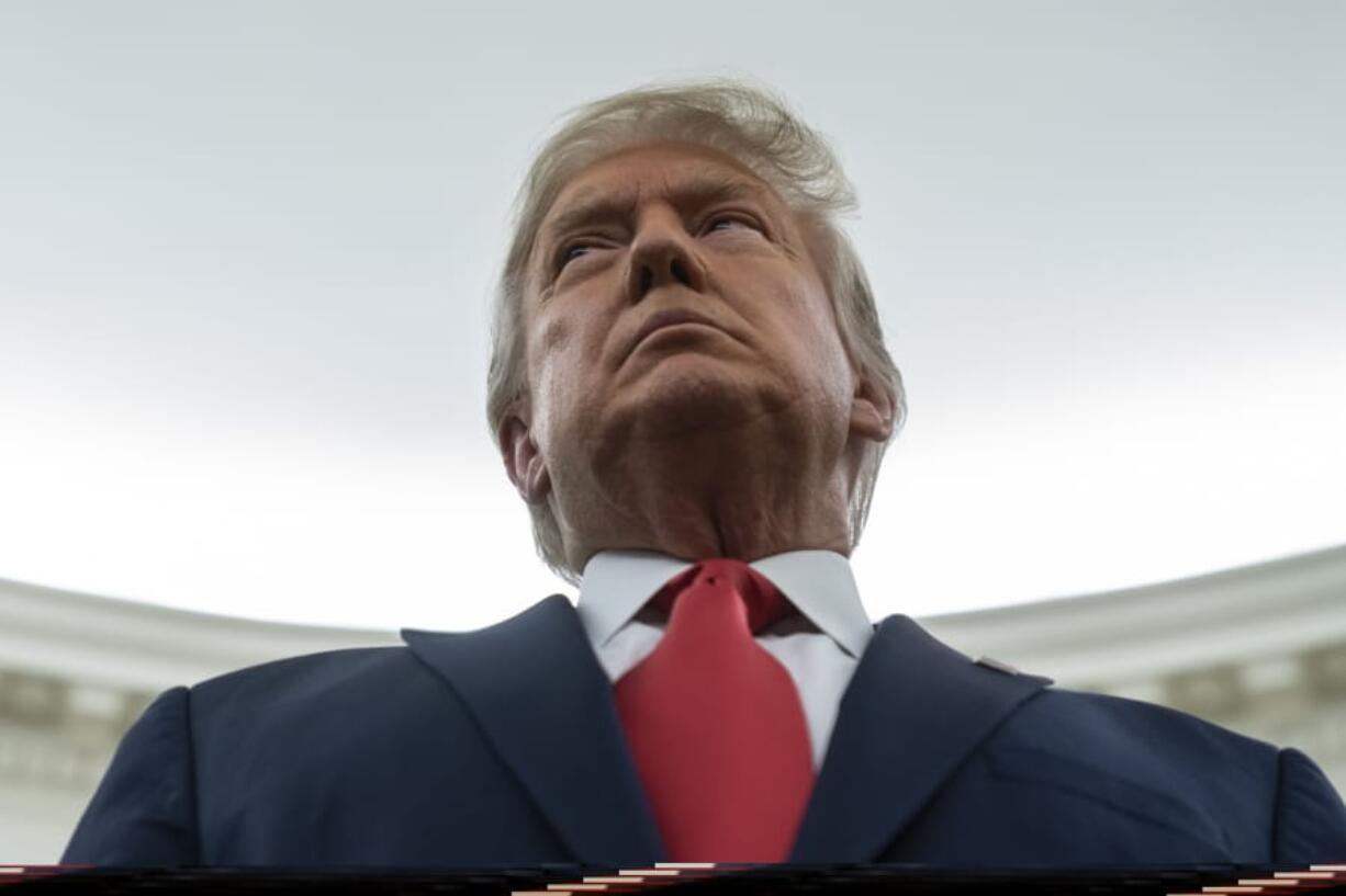 President Donald Trump listens during a ceremony to present the Presidential Medal of Freedom to former football coach Lou Holtz, in the Oval Office of the White House, Thursday, Dec. 3, 2020, in Washington.