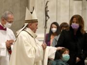 Pope Francis caresses a boy as he arrives to celebrate Mass on Christmas eve, at St. Peter&#039;s basilica at the Vatican, Thursday, Dec. 24, 2020.