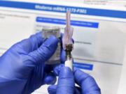 FILE - In this Monday, July 27, 2020 file photo, a nurse prepares a syringe during a study of a possible COVID-19 vaccine, developed by the National Institutes of Health and Moderna Inc., in Binghamton, N.Y. With coronavirus vaccines on the horizon, when and where will most Americans get their shots? Many of the details are still being worked out, as regulators review the first vaccine candidates. A federal panel of vaccine experts is meeting this week to consider Pfizer&#039;s vaccine, and again next week for Moderna&#039;s.