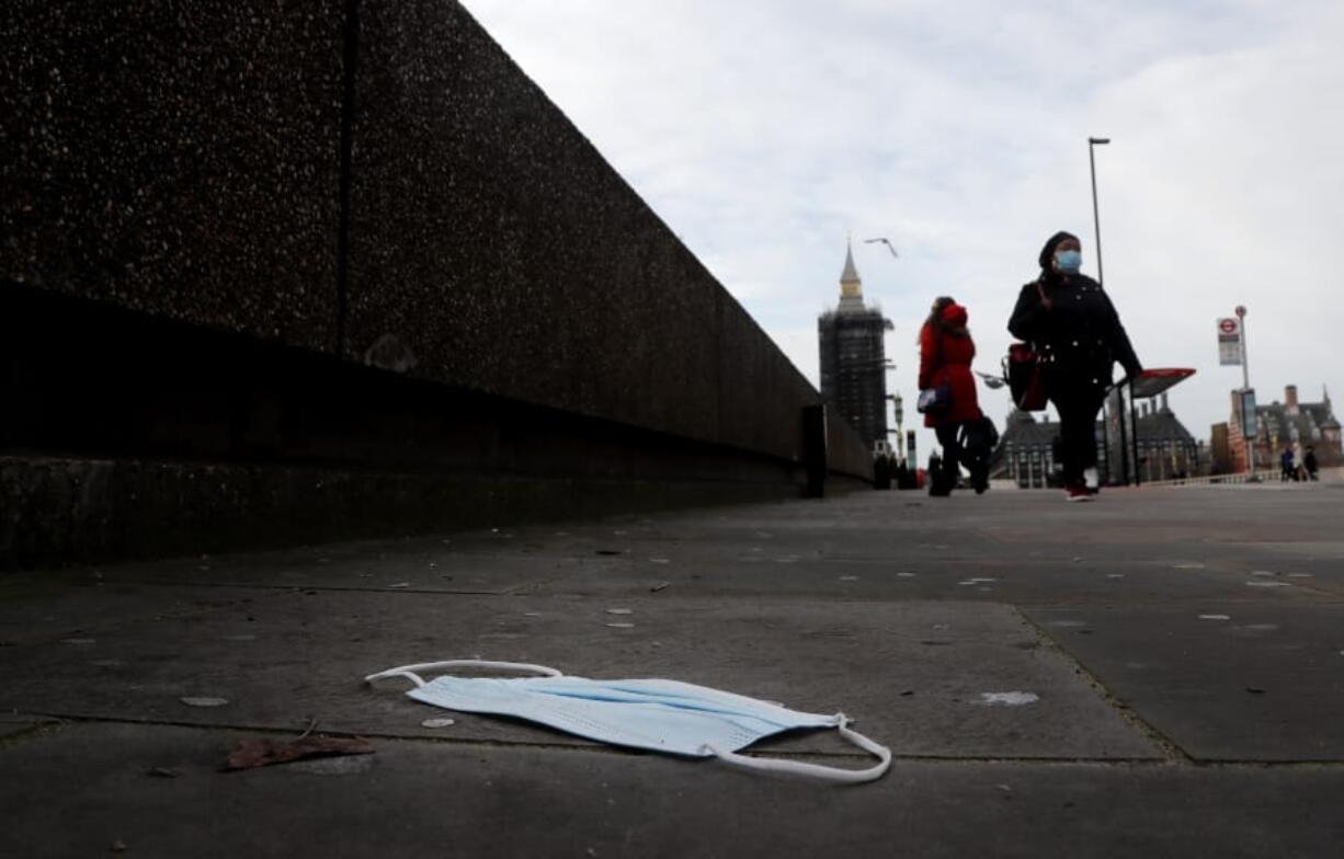 A mask on the pavement near the entrance of a hospital on Westminster Bridge in London, Wednesday, Dec. 30, 2020.