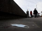 A mask on the pavement near the entrance of a hospital on Westminster Bridge in London, Wednesday, Dec. 30, 2020.