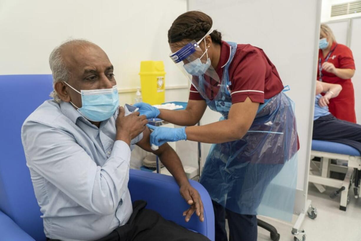 Care home worker Pillay Jagambrun, 61, receives the Pfizer/BioNTech COVID-19 vaccine in The Vaccination Hub at Croydon University Hospital, south London, on the first day of the largest immunization program in the UK&#039;s history, Tuesday Dec. 8, 2020.