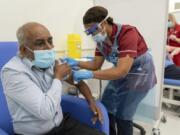 Care home worker Pillay Jagambrun, 61, receives the Pfizer/BioNTech COVID-19 vaccine in The Vaccination Hub at Croydon University Hospital, south London, on the first day of the largest immunization program in the UK&#039;s history, Tuesday Dec. 8, 2020.