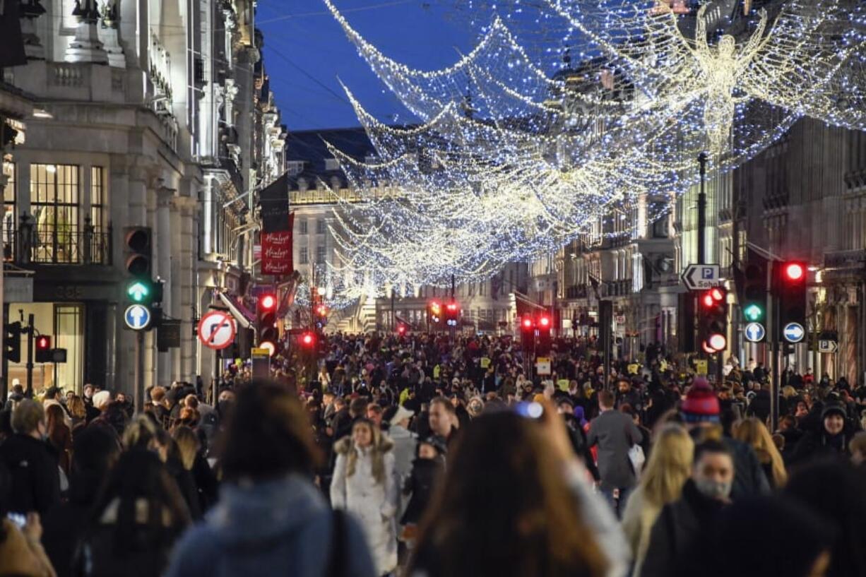 Shoppers wear face masks as they walk in Regent Street, ahead of the new Tier-4 restriction measures, in London, Saturday, Dec. 19, 2020.