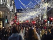 Shoppers wear face masks as they walk in Regent Street, ahead of the new Tier-4 restriction measures, in London, Saturday, Dec. 19, 2020.