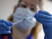 A nurse prepares a shot of the Pfizer-BioNTech COVID-19 vaccine at Guy&#039;s Hospital in London, Tuesday, Dec. 8, 2020, as the U.K. health authorities rolled out a national mass vaccination program.  U.K. regulators said Wednesday Dec. 9, 2020, that people who have a &quot;significant history&#039;&#039; of allergic reactions shouldn&#039;t receive the new Pfizer/BioNTech vaccine while they investigate two adverse reactions that occurred on the first day of the country&#039;s mass vaccination program.