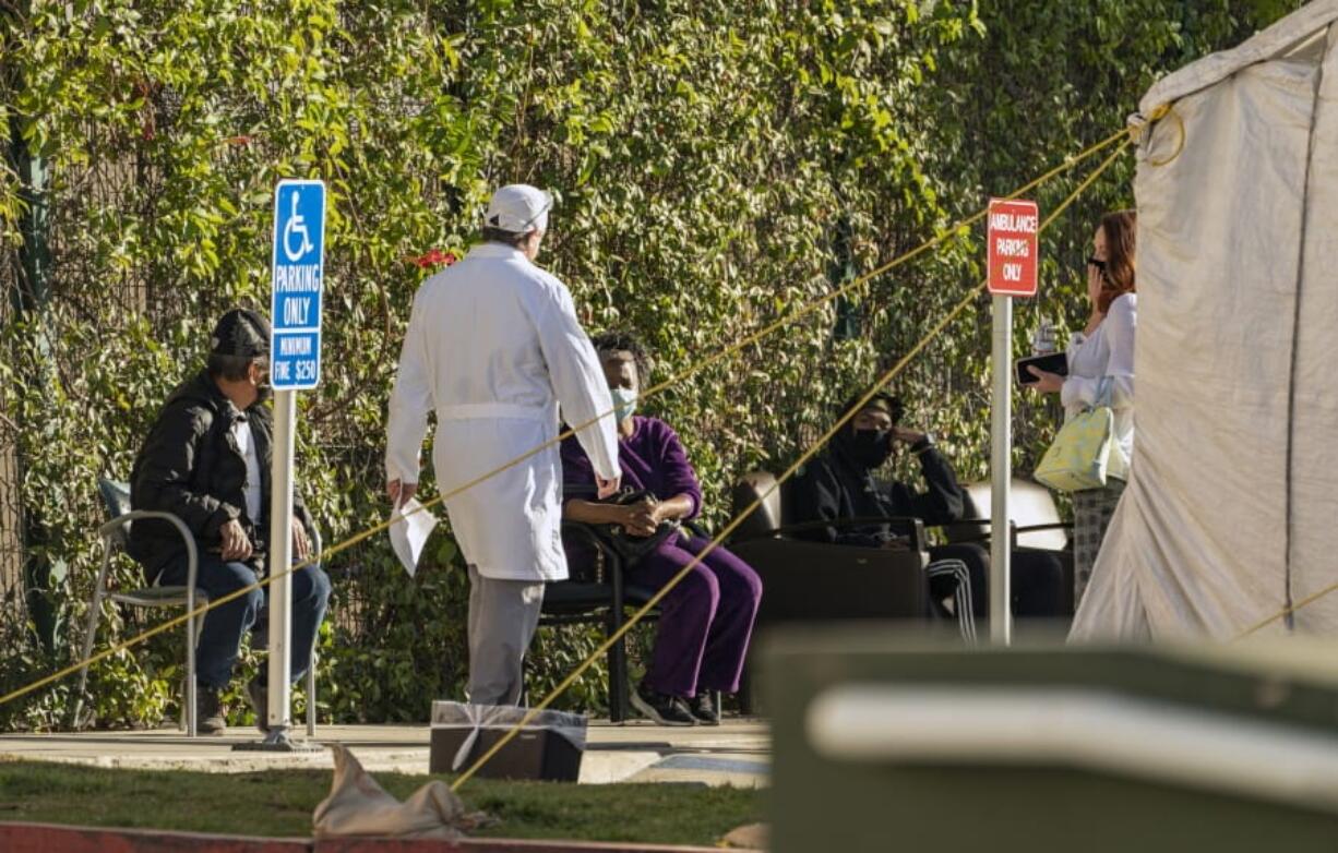 Patients wait in line for medical evaluation next to medical tents set at the CHA Hollywood Presbyterian Medical Center in Los Angeles Friday, Dec. 18, 2020. Increasingly desperate California hospitals are being &quot;crushed&quot; by soaring coronavirus infections, with one Los Angeles emergency doctor predicting that rationing of care is imminent. The most populous state recorded more than 41,000 new confirmed cases and 300 deaths, both among the highest single-day totals during the pandemic. In the last week, California has reported more than a quarter-million cases and 1,500 deaths.