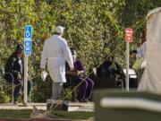 Patients wait in line for medical evaluation next to medical tents set at the CHA Hollywood Presbyterian Medical Center in Los Angeles Friday, Dec. 18, 2020. Increasingly desperate California hospitals are being &quot;crushed&quot; by soaring coronavirus infections, with one Los Angeles emergency doctor predicting that rationing of care is imminent. The most populous state recorded more than 41,000 new confirmed cases and 300 deaths, both among the highest single-day totals during the pandemic. In the last week, California has reported more than a quarter-million cases and 1,500 deaths.