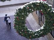 Shoppers wear face masks while in search of after-Christmas bargains in shops in the Denver Pavilions Tuesday, Dec. 29, 2020, in downtown Denver.