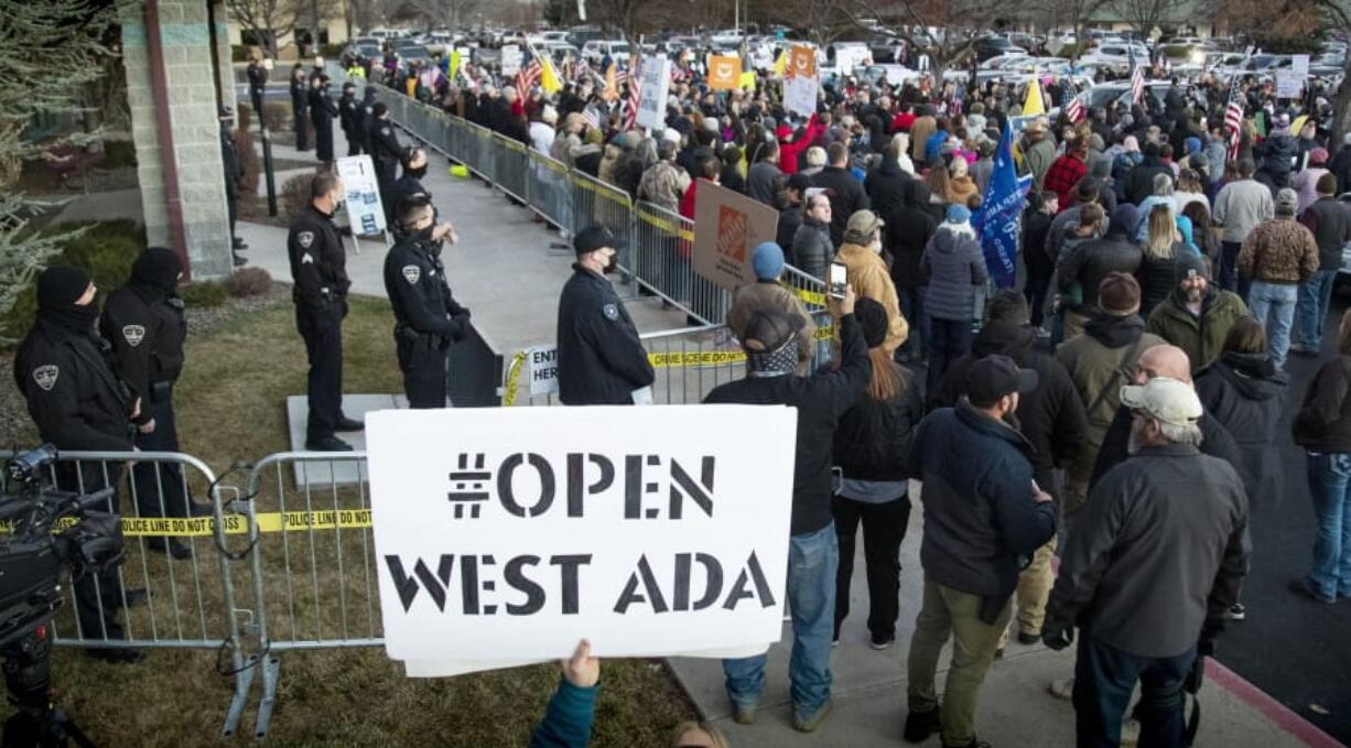 Boise police were forced to create a barrier to keep anti-mask protesters from entering a meeting at the Central District Health offices, Tuesday, Dec. 8, 2020 in Boise, Idaho. The special meeting of the CDH board was later cancelled.