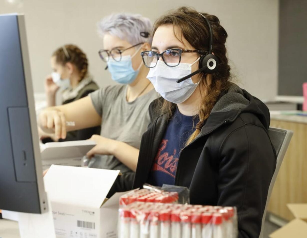 Employees schedule COVID-19 tests and prepare test kits at Primary Health Medical Group&#039;s clinic in Boise, Idaho, on Tuesday, Nov. 24, 2020. Troops direct people outside the urgent-care clinic revamped into a facility for coronavirus patients as infections and deaths surge in Idaho and nationwide.