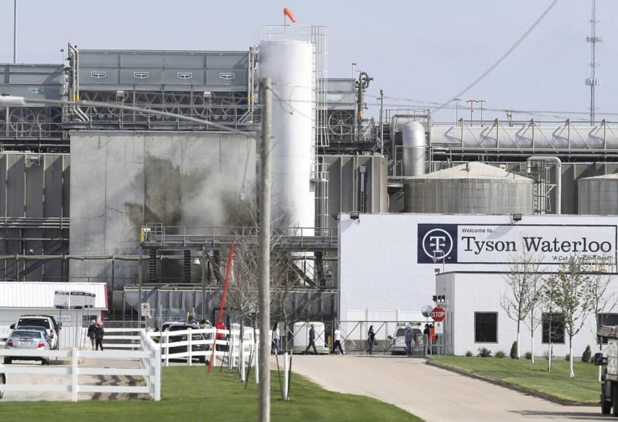 FILE - In this May 2020, file photo, Tyson&#039;s Fresh Meat workers file in for a tour of safety measures put into place after the plant in Waterloo, Iowa, had to shut down due to a COVID-19 outbreak. The family of a Tyson Foods employee are alleging in a lawsuit that he died from COVID-19 after the meat processing giant failed to implement safety protocols to guard against the coronavirus at the Iowa plant where he worked.