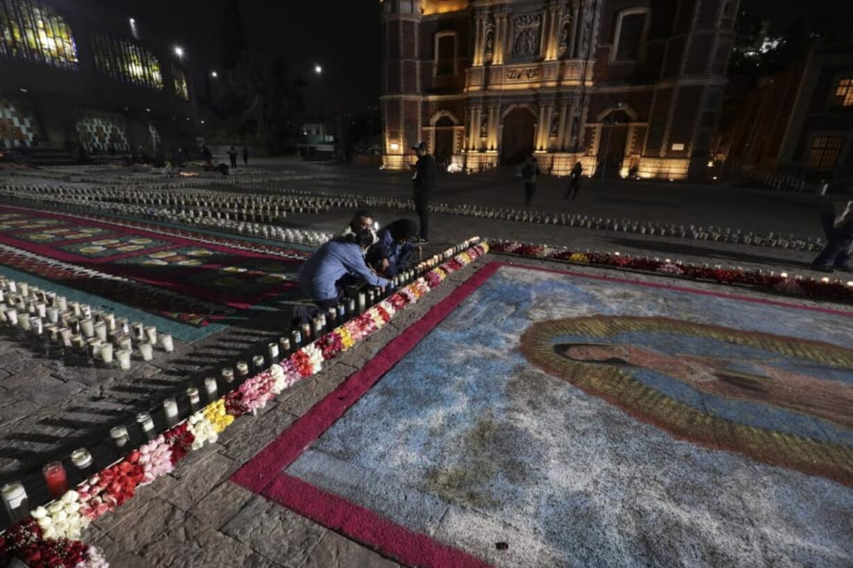 People lights a candle next to an image the Virgin of Guadalupe outside the Basilica of Guadalupe in Mexico City, Friday, Dec. 11, 2020. Nationwide, devotees of the Virgin make a pilgrimage to the Basilica in honor of her Dec. 12 feast day, but the Catholic Church announced the closure of the Basilica for this year&#039;s pilgrimage due to the coronavirus pandemic.