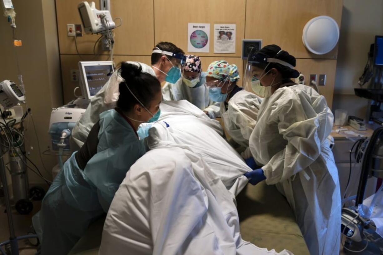 FILE - In this Nov. 19, 2020, file photo, medical personnel prone a COVID-19 patient at Providence Holy Cross Medical Center in the Mission Hills section of Los Angeles. Across the U.S., the surge has swamped hospitals with patients and left nurses and other health care workers shorthanded and burned out. (AP Photo/Jae C.