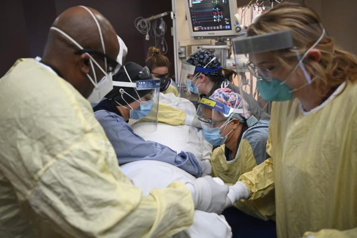 Critical care nurses and respiratory therapists flip a patient with COVID-19 upright Monday at North Memorial Health Hospital in Robbinsdale, Minn. Virtually every state is reporting surges in cases and deaths.