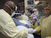 Critical care nurses and respiratory therapists flip a patient with COVID-19 upright Monday at North Memorial Health Hospital in Robbinsdale, Minn. Virtually every state is reporting surges in cases and deaths.