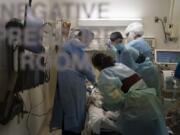 EMT Giselle Dorgalli, second from right, looks at a monitor Nov. 19 while performing chest compressions on a patient who tested positive for coronavirus in the emergency room at Providence Holy Cross Medical Center in the Mission Hills section of Los Angeles. (Jae C.