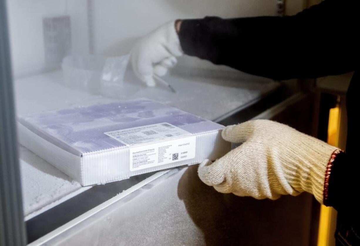 University of Washington Medical Center Pharmacy Manager Christine Meyer puts a tray of doses of the Pfizer-BioNTech COVID-19 vaccine into the deep freeze after the vaccine arrived Monday at the University of Washington Medical Center&#039;s Montlake campus in Seattle.