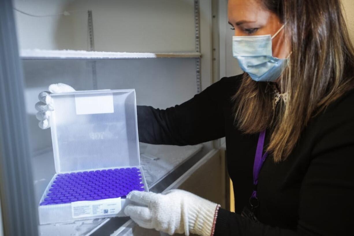 University of Washington Medical Center Pharmacy Manager Christine Meyer puts a tray of doses of the Pfizer-BioNTech COVID-19 vaccine into the deep freeze after the vaccine arrived at the University of Washington Medical Center&#039;s Montlake campus Monday, Dec. 14, 2020, in Seattle.