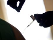 FILE - In this Tuesday, Dec. 15, 2020, file photo, a droplet falls from a syringe after a health care worker was injected with the Pfizer-BioNTech COVID-19 vaccine at a hospital in Providence, R.I. The U.S. COVID-19 vaccination campaign has begun, and the few available doses are mostly going into the arms of health care workers and nursing home residents. But what about in January, February and March, when more shots are expected to become available? Who should get those doses?