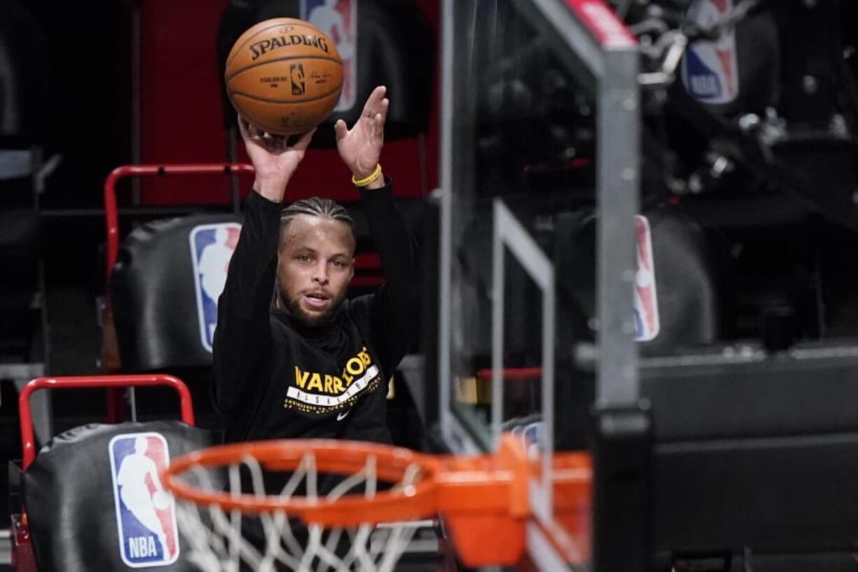 Golden State Warriors guard Stephen Curry shoots as players warm up for the team&#039;s NBA basketball game against the Brooklyn Nets, Tuesday, Dec. 22, 2020, in New York.