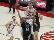 Utah center Branden Carlson (35) defends against Washington guard Quade Green (55) as he goes to the basket during the first half of an NCAA college basketball game Thursday, Dec. 3, 2020, in Salt Lake City.