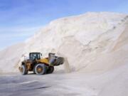 A front loader works at a large pile of road salt, Wednesday, Dec. 16, 2020, in Chelsea, Mass., as preparation continues for a storm that is expected to dump a foot or more of snow throughout the Northeast.