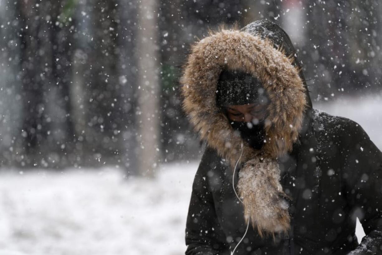 FILE - In this Dec. 17, 2020, file photo, a woman walks through a snowstorm in the Bronx borough of New York.