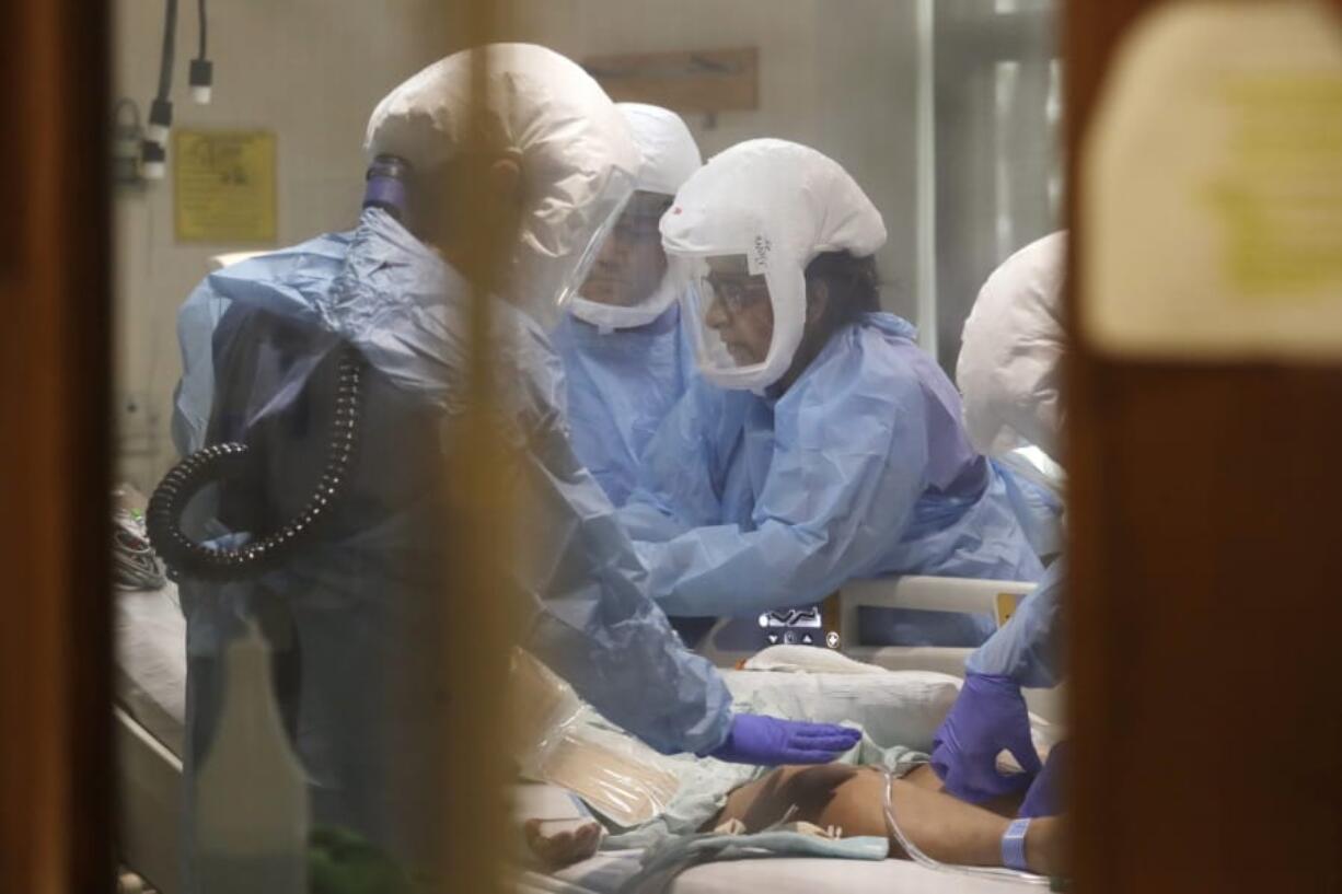 FILE - In this May 8, 2020, file photo, respiratory therapist Neeru Kaur, right, and other medical staff work on a patient in the COVID-19 Intensive Care Unit at Harborview Medical Center, which is part of Seattle-area health care system UW Medicine, in Seattle. The COVID-19 pandemic was Washington state&#039;s top story for 2020.