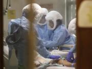 FILE - In this May 8, 2020, file photo, respiratory therapist Neeru Kaur, right, and other medical staff work on a patient in the COVID-19 Intensive Care Unit at Harborview Medical Center, which is part of Seattle-area health care system UW Medicine, in Seattle. The COVID-19 pandemic was Washington state&#039;s top story for 2020.