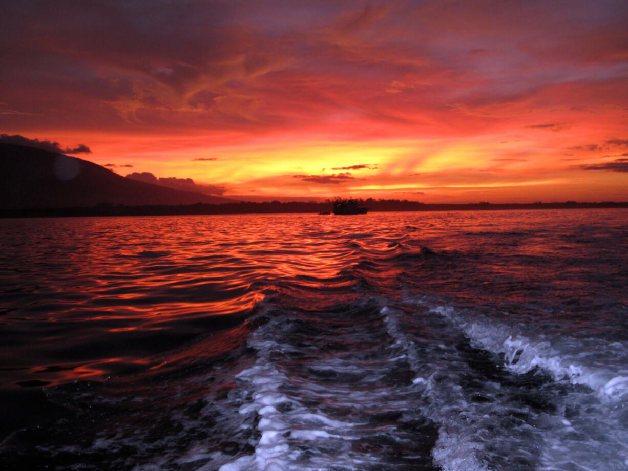 The setting sun fills the sky with color over Fernandina in the Galapagos Islands.