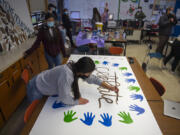 Mountain View High School junior Makaila Inoncilo, 16, foreground, joins fellow leadership student Nancy Flores, 16, also a junior, while creating a mural with a positive message. The murals created by the leadership students will be displayed on campus.