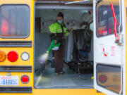 WOODLAND: Mary Martin, a KWRL driver, uses an electrostatic sprayer to clean buses.