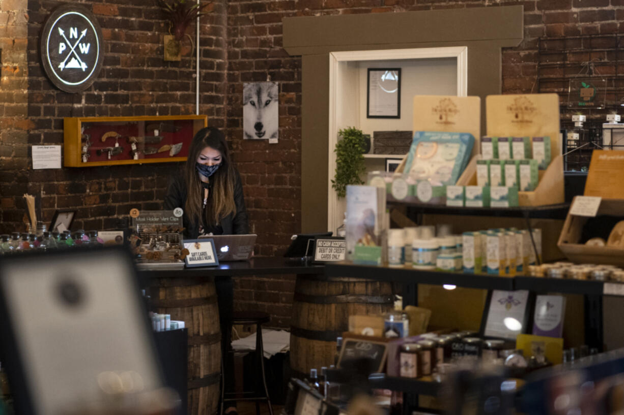 Store owner Jessica Chan works on her laptop Saturday at NMV Pop-Local on West Ninth Street in downtown Vancouver.