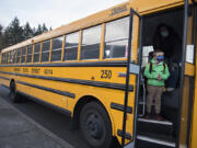 First-grader Kolby Schave, 6, prepares to depart the school bus while arriving for hybrid classes at Crestline Elementary School on Tuesday morning.