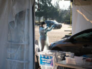 Staffer Allison Berhow instructs a driver to self-administer an oral COVID-19 test Saturday at the new Tower Mall drive-thru testing site. Visitors receive their results in two or three days.