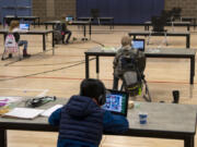 Students work in the "Internet Cafe" at Captain Strong Primary School in Battle Ground in January. Students are set up with Chromebooks in the gymnasium if they need internet to access remote learning.