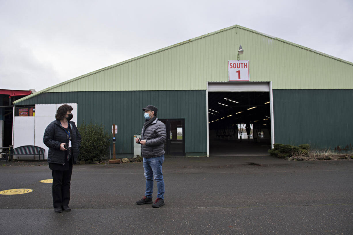 Tawnia Linde, marketing director for Clark County Event Center at the Fairgrounds, left, talks with fairgrounds public relations manager Jim Beriault on Monday afternoon, January 25, 2021, while standing outside the building that will be used for drive-through COVID-19 vaccinations starting Tuesday. The vaccinations are by appointment only.