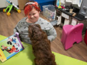 Aurora, the daughter of a resident at the Homestead Share House, and her dog Koda play in a toy room at the newly renovated shelter  on Wednesday afternoon.