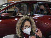 Tram Nguyen, an intern with Safeway, foreground, prepares doses of COVID-19 vaccine for visitors in line such as Peggy and Bob Swenson of Camas, background, at the Clark County Event Center at the Fairgrounds on Tuesday morning, January 26, 2021.