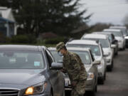 Israel De La Cruz of the National Guard helps direct motorists as they prepare to get their COVID-19 vaccine at the Clark County Event Center at the Fairgrounds on Tuesday morning, January 26, 2021.