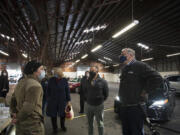 Pvt. Brei Plumb, who is a medic in the Washington National Guard, left, talks with Washington Secretary of Health Dr. Umair Shah, second from right, and Gov. Jay Inslee, right, as they tour the mass vaccination site at the Clark County Fairgrounds on Thursday morning, January 28, 2021.