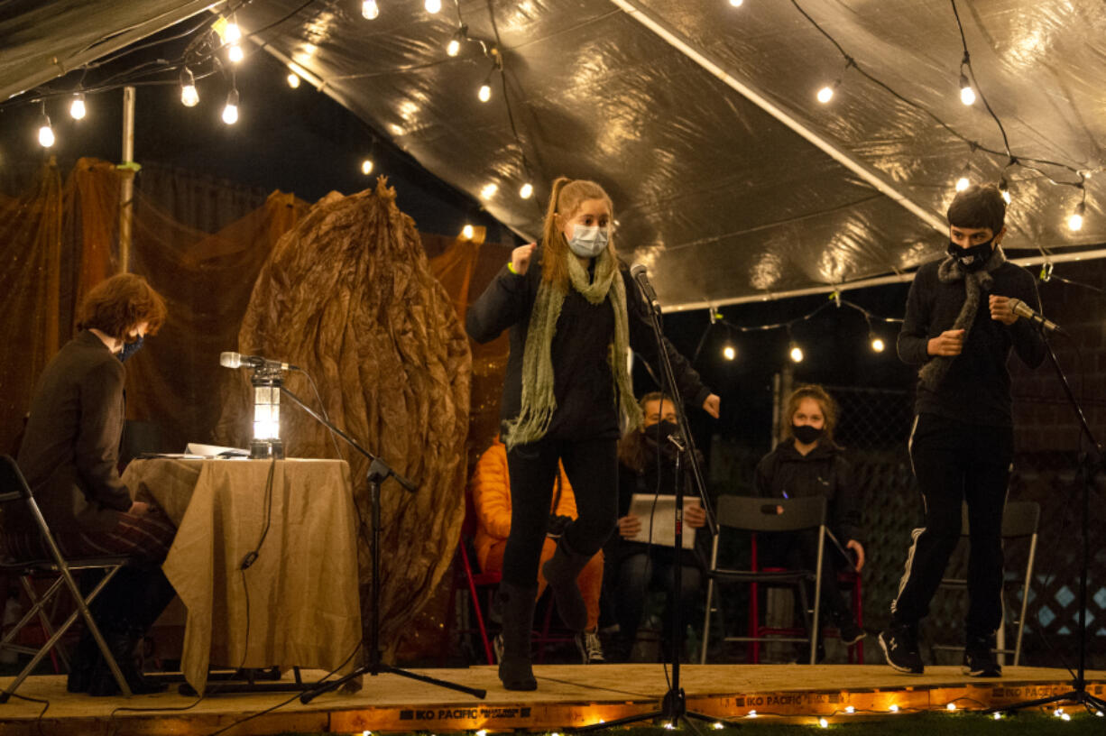 Parielle Shapard as the old green grasshopper, center, and Nick Campos as the centipede perform during Friday night&#039;s staged reading of &quot;James and the Giant Peach,&quot; by Downstage Center Productions, at The Historic Academy in downtown Vancouver. That&#039;s a giant peach pit behind them, of course.