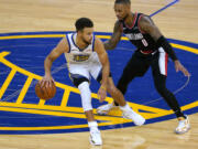 Golden State Warriors guard Stephen Curry (30) dribbles past Portland Trail Blazers guard Damian Lillard (0) during the second half of an NBA basketball game in San Francisco, Friday, Jan. 1, 2021. Portland won 123-98.